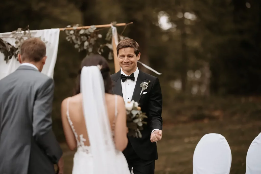 Bräutigam empfängt seine Braut während der Trauung unter freiem Himmel