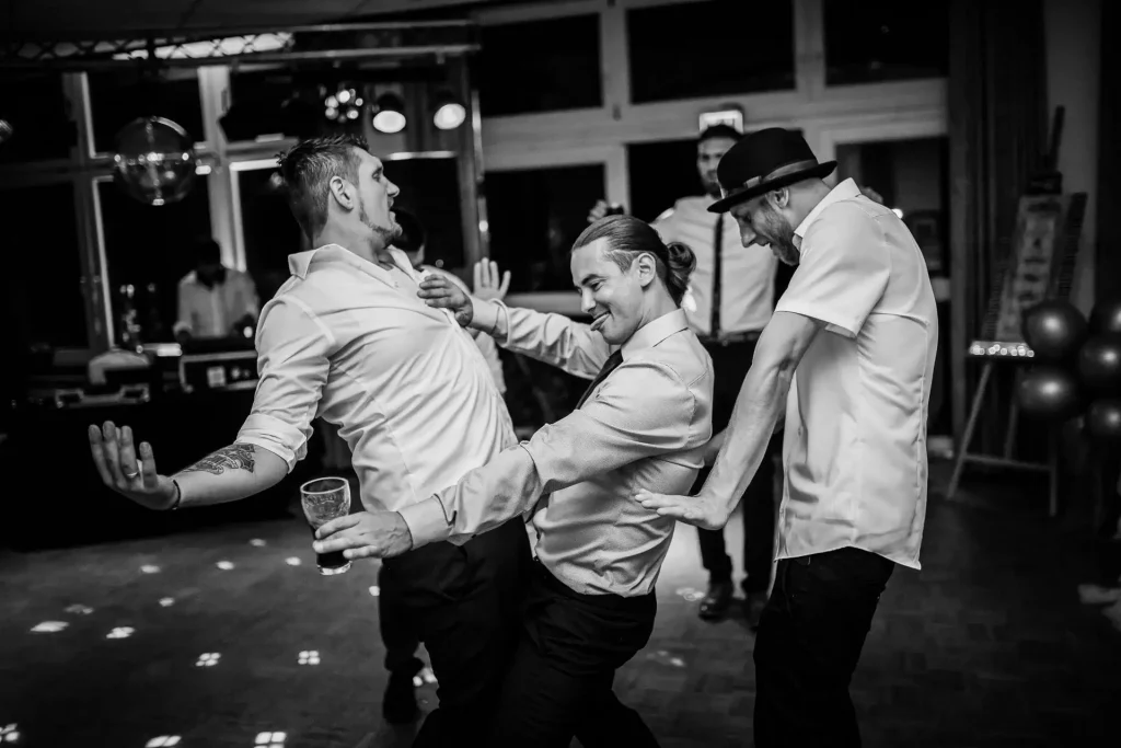 Junge Männer tanzen ausgelassen auf der Tanzfläche