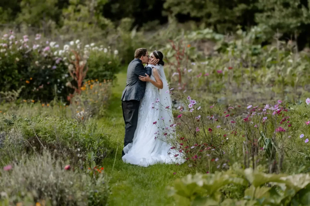 Bräutigam küsst seine Braut im Freien